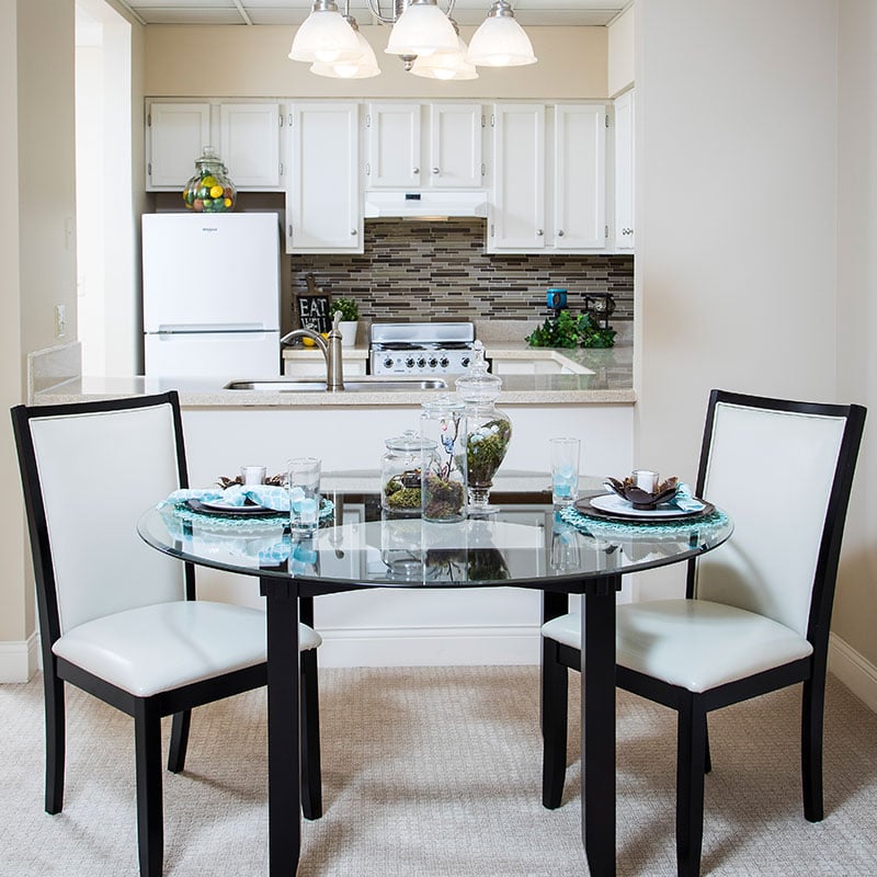 A-cross-section-of-a-cozy-dining-corner-showing-the-kitchen-area-as-well-at-10-Wilmington-Place-Senior-Living