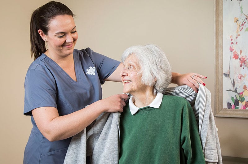 A-kind-nurse-assists-a-10-Wilmington-Place-resident-in-wearing-their-coat (1)