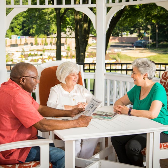 senior living residents of 10 wilmington place enjoy each others company on the outdoor gazebo