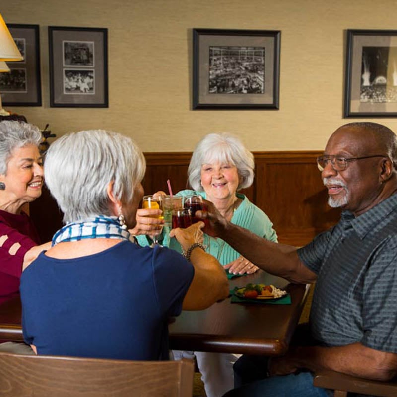 residents at 10 wilmington place enjoying a meal together in the dining area and raising their glasses to toast