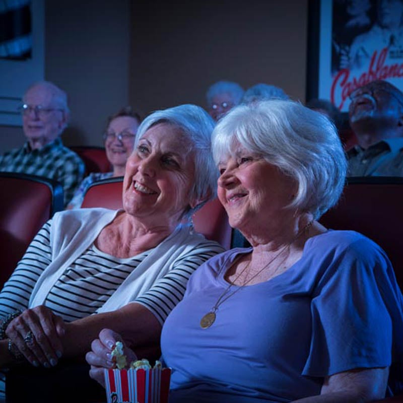 two senior ladies enjoying a movie in the cinema
