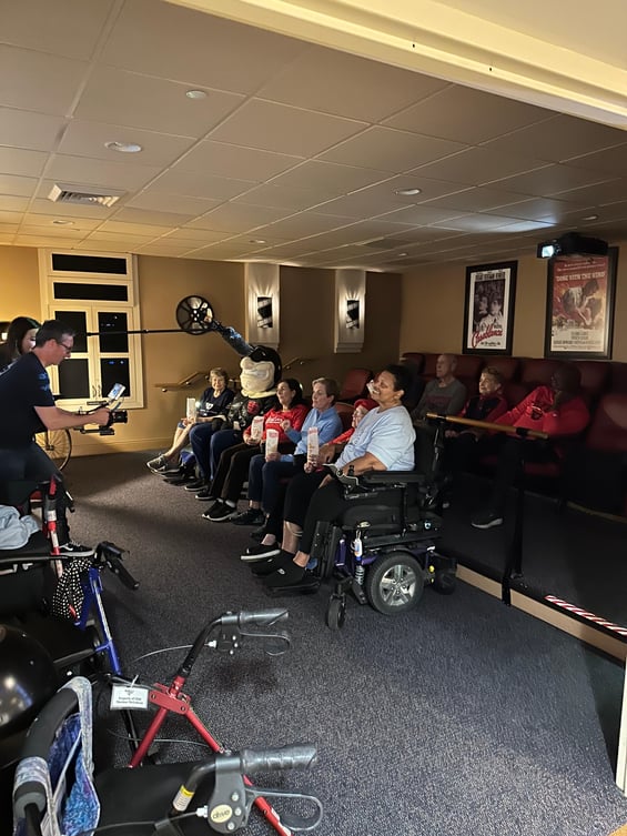 Seniors sitting in a movie theater eating popcorn being filmed for a commercial