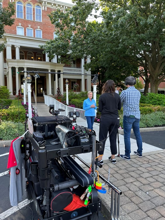 A senior being filmed standing outside of 10 Wilmington Place