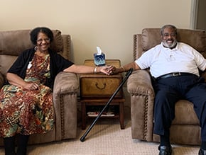 Residents at 10 Wilmington Place Sitting on comfortable recliners holding hands and smiling