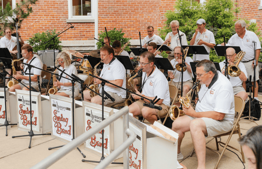 A band plays in an outdoor summer concert amphitheater