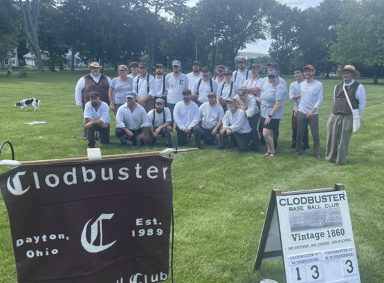 The Clod Busters base ball team is shown on a large front lawn