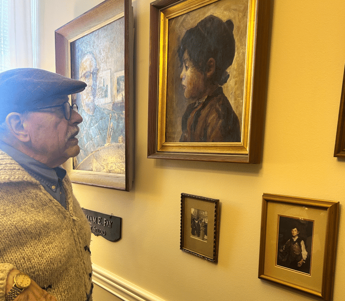 Dr. John Remick looks at his unique artwork on the wall of his apartment